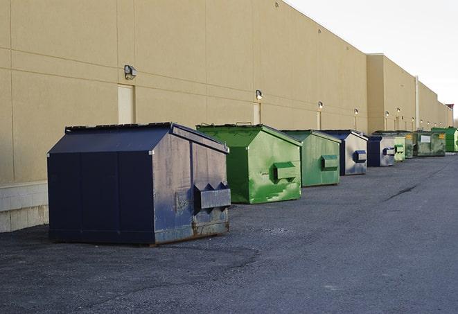 a construction worker moves construction materials near a dumpster in East Palatka